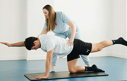 A physical therapist assisting a patient with a leg extension exercise